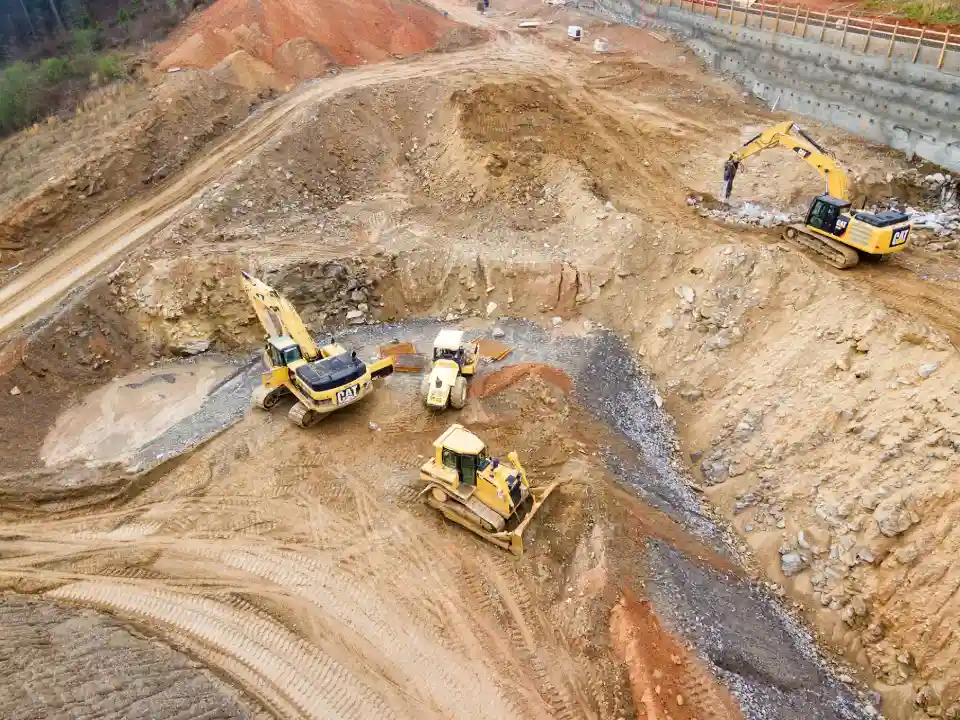 Baumaschinen und Bagger auf einer Baustelle in einem Erdloch